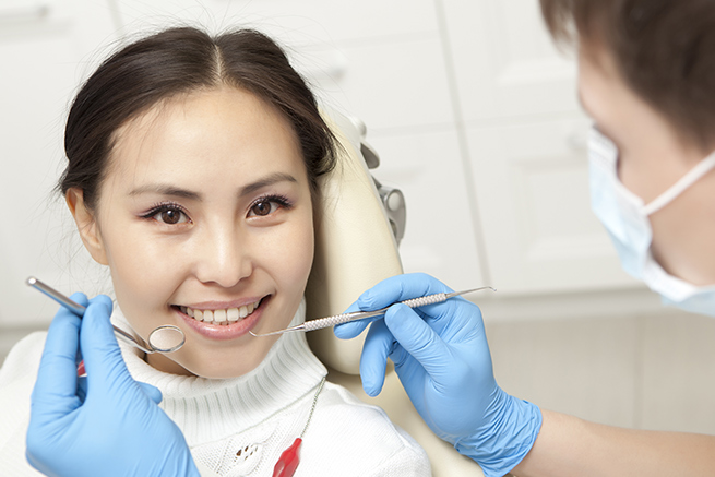 Patient Smiling, Dentist holding dental instruments