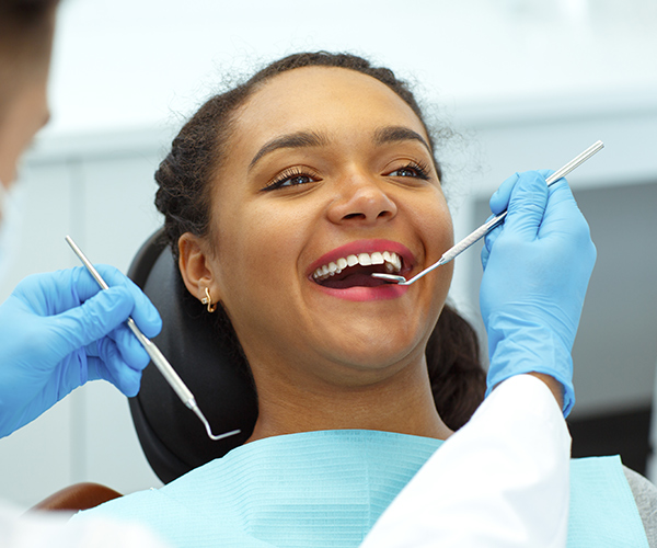 Patient getting her teeth checkup by a dentist, Dental instruments