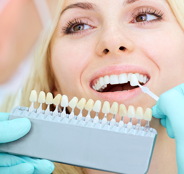 Patient having a checkup to match desired color of her teeth