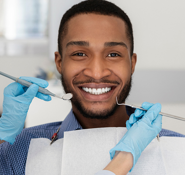 Patient smiling, Hand of dentist holding dental equipment to check patients teeth
