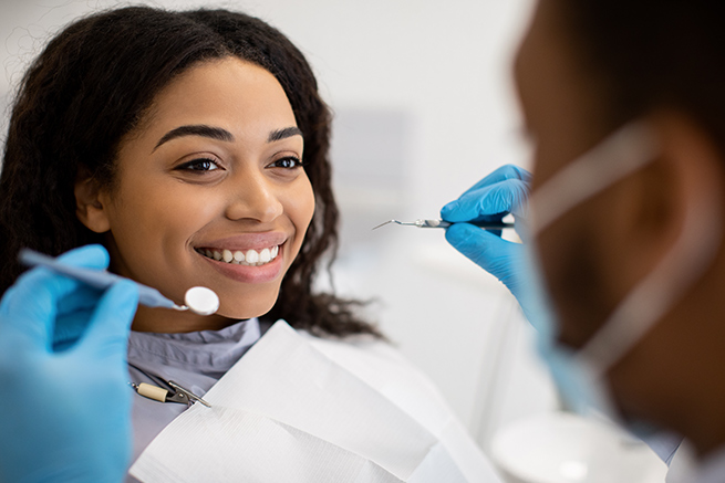 Woman smiling, Woman about to checkup by a dentist, Dentist holding dental instruments