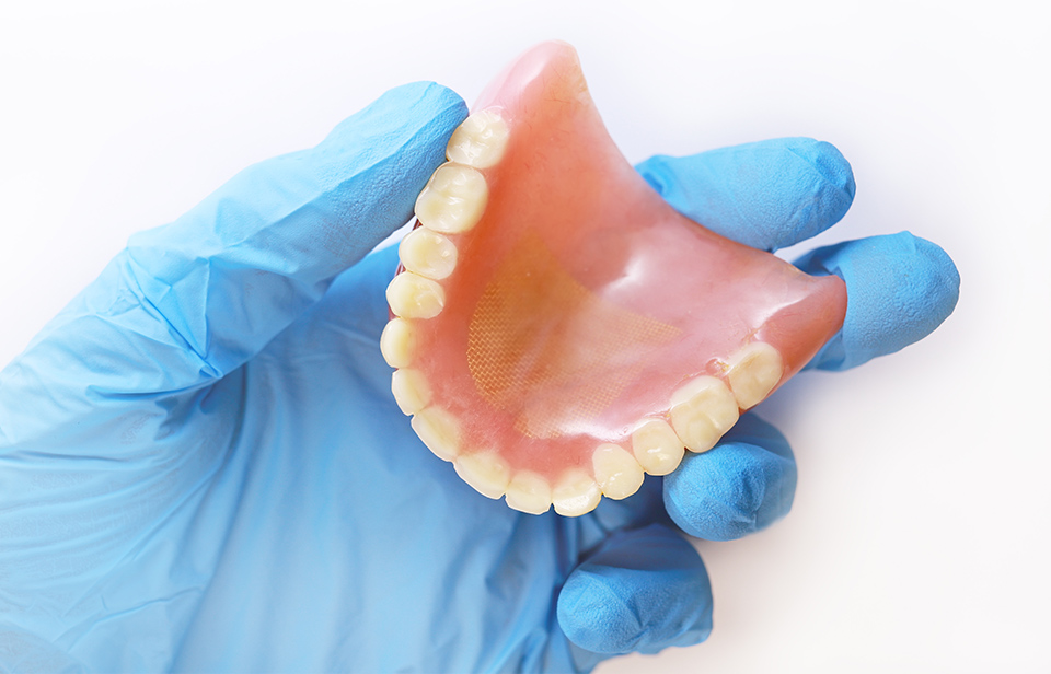 Dentist hand holding denture