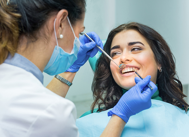 Woman patient getting her teeth checked by the dentist