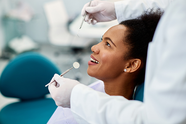 Woman patient getting her teeth checked by the dentist